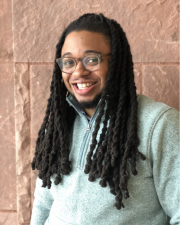 Image of Ricky Pulley Jr smiling in a light green sweater.